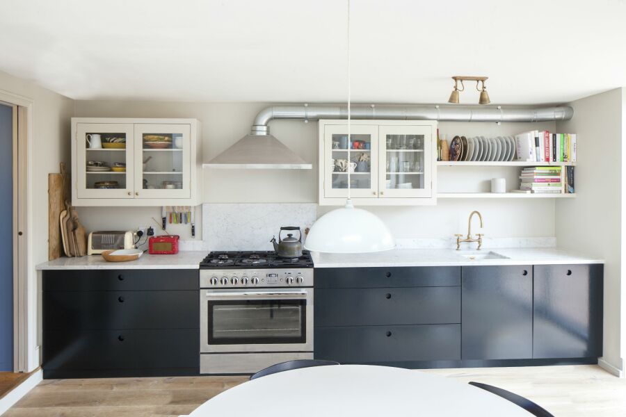 Modern kitchen with dark cupboard doors and a marble worktop.