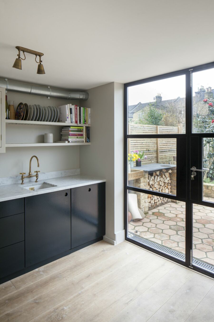 Kitchen with crittall window style doors leading to garden.